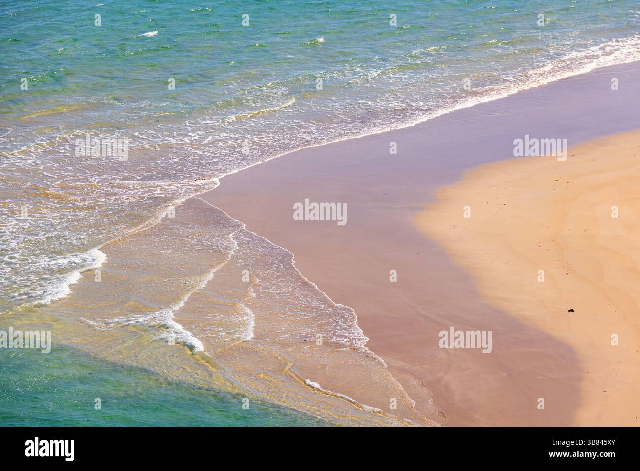 Blick auf die brechenden Meereswellen an einem Sandstrand Stockfoto