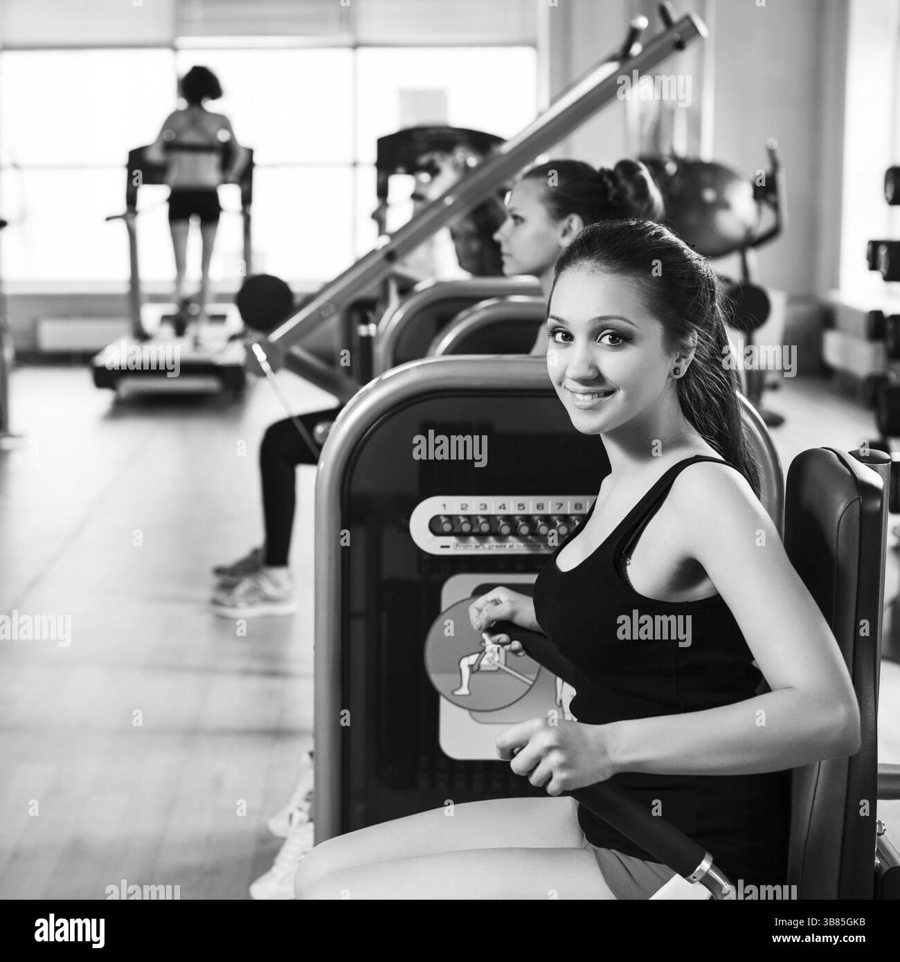 Fitness-Center im Innenbereich, in dem junge Frauen Gewichte mit Händen trainieren Stockfoto
