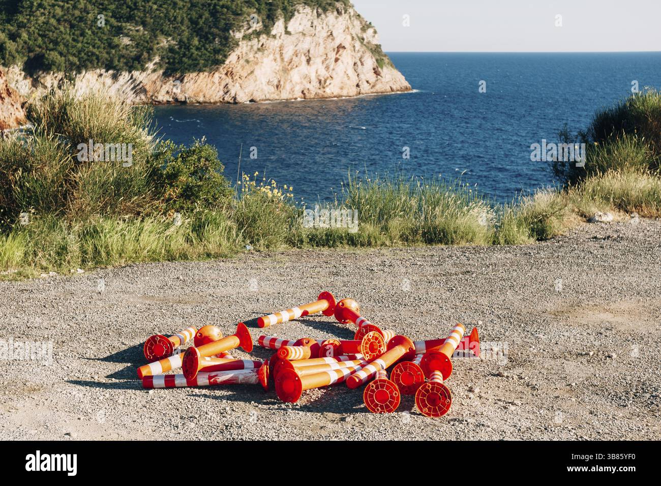 Auf der Straße sind orangefarbene Straßenbegrenzer aufgestapelt. Stockfoto