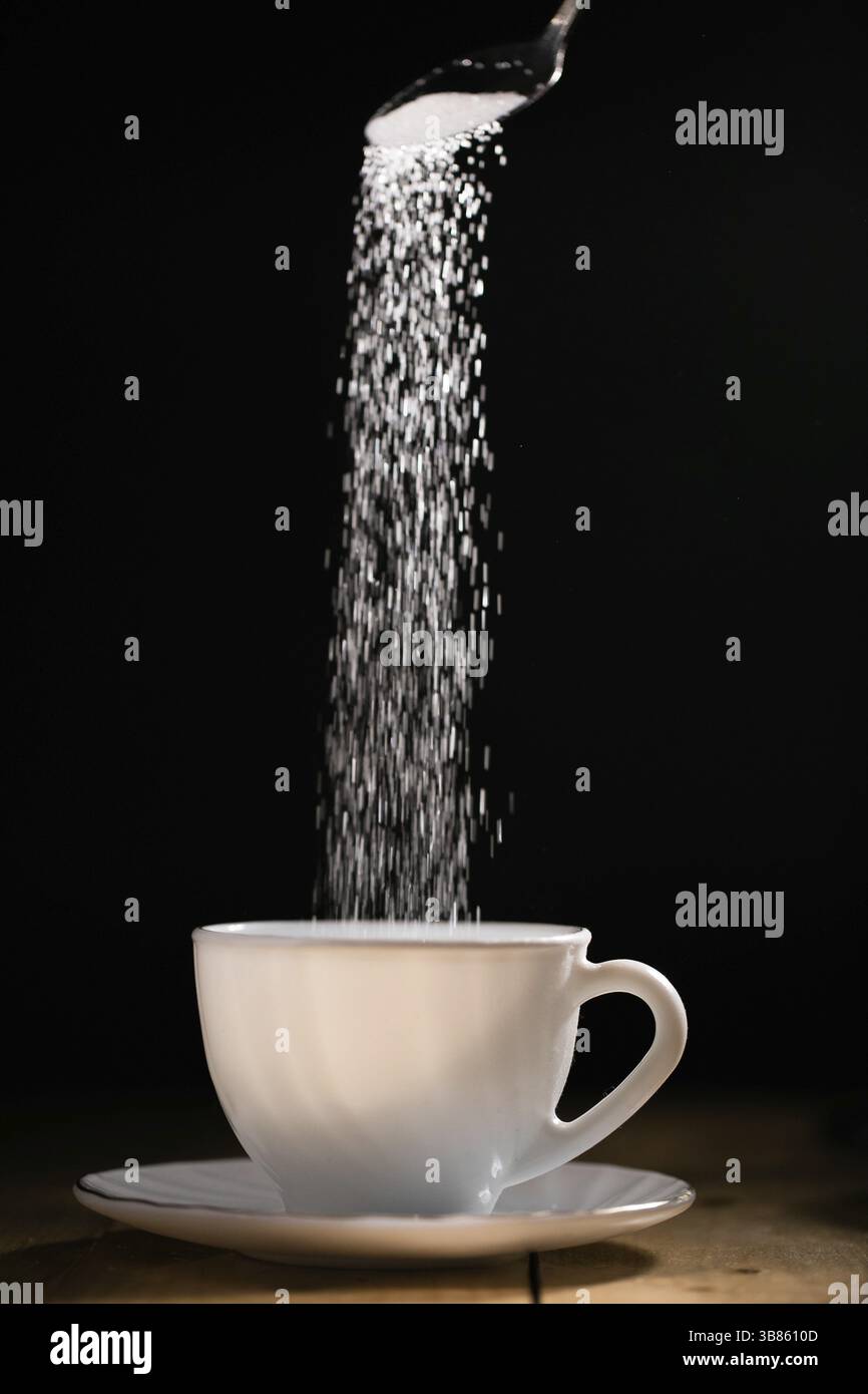 Kristallzucker in eine weiße Schale gießen Stockfoto