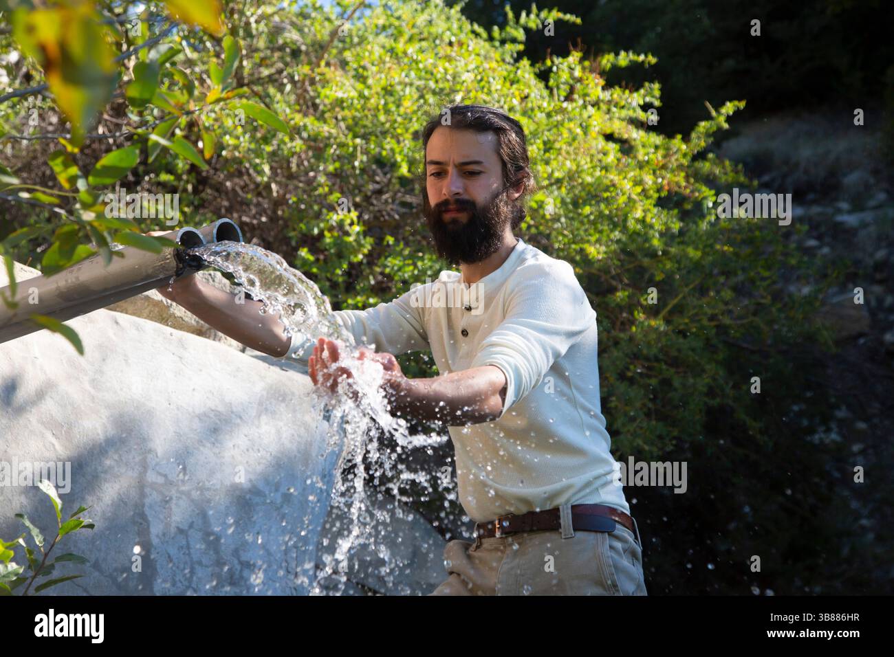 7. Oktober 2023 – Lake Arrowhead, Kalifornien, USA – der Aktivist Bridger Zadina macht ein eindrucksvolles Bild, das den Fluss des Quellwassers aus der BlueTriton-Pfeife im San Bernardino National Forest enthüllt. Dieses Wasser dient einem wichtigen Zweck, da das Unternehmen verpflichtet ist, eine bestimmte Menge freizusetzen, um die Tierwelt in der Region zu unterstützen. Allerdings wurde eine kürzlich durchgeführte Studie eingeleitet, um eine abgelaufene Sondergenehmigung zu untersuchen, die der Arrowhead Water Flaschenfirma die Erlaubnis einräumt, ganzjährig Quellwasser aus Strawberry Creek innerhalb des Waldes zu sammeln. Dieses Wasser wird durch stabile Stahlrohre transportiert Stockfoto