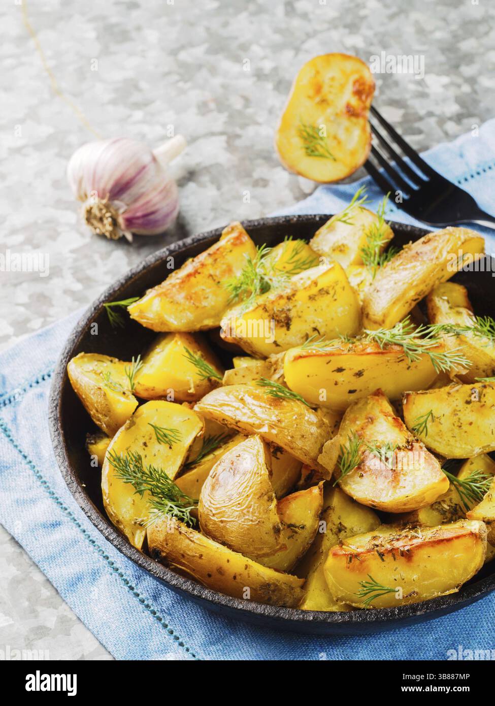 Nahaufnahme der Backkartoffeln in Gusseisen-Skillet Stockfoto