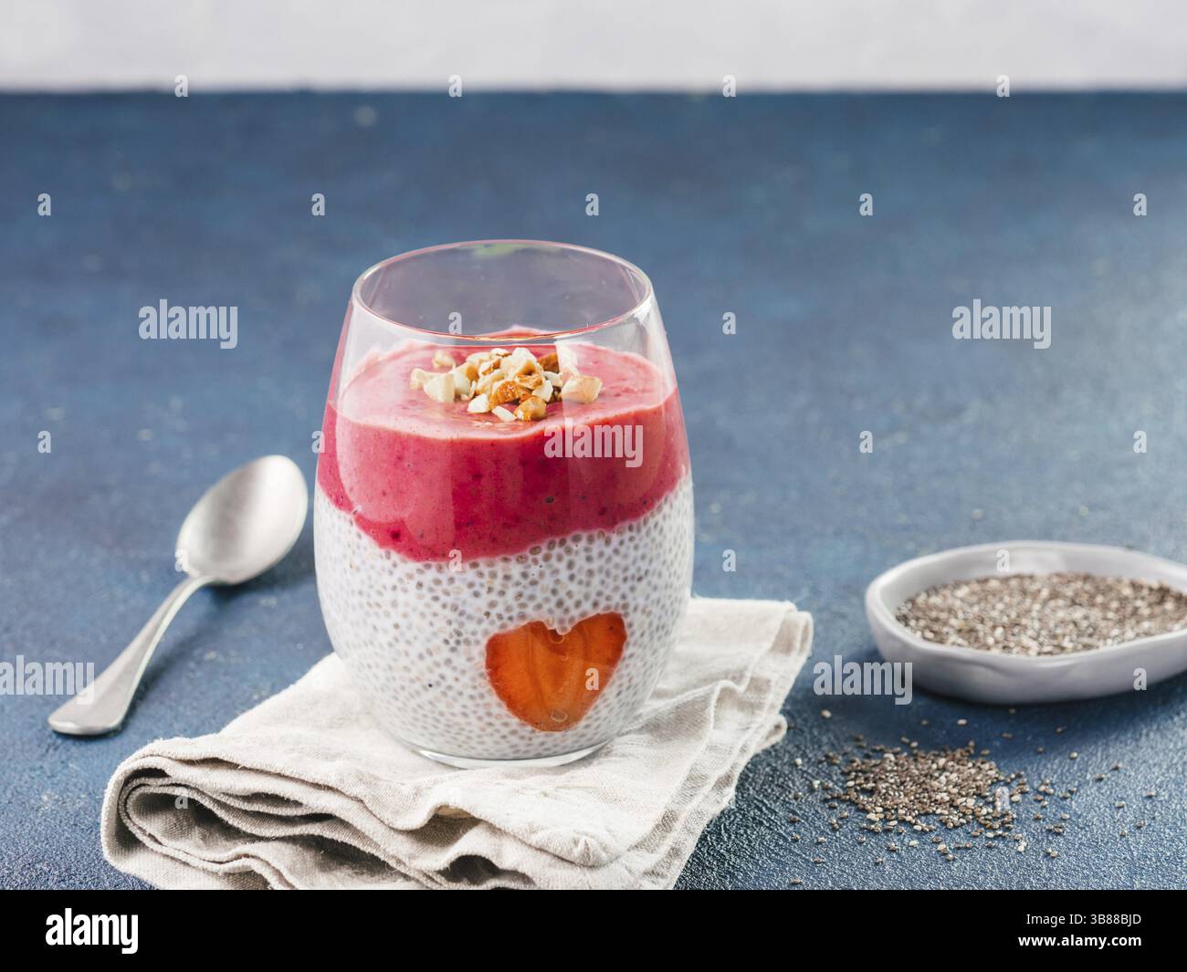 Idee für gesundes Frühstück am Valentinstag: Chia Pudding mit roten Beeren Püree, gehackte Mandeln auf und Erdbeere in der Form des Herzens. Kopieren Sie sp Stockfoto