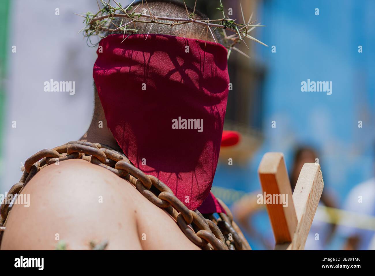 Nahaufnahme des Kopfes eines Mannes während der Engrillados-Tradition in Atlixco, Mexiko. Die Dornenkrone und das rot bedeckte Gesicht symbolisieren Glauben und Schmerz Stockfoto