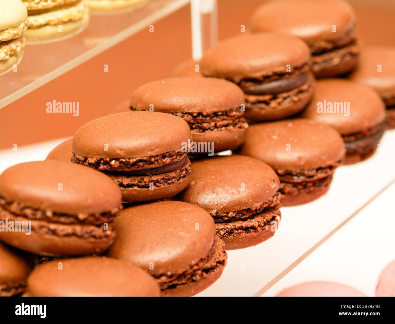 Elegante Schokoladen-Macarons mit glatter Ganache-Füllung, klassische französische Konditorei, serviert als raffiniertes Dessert oder süßer Leckerbissen. Stockfoto