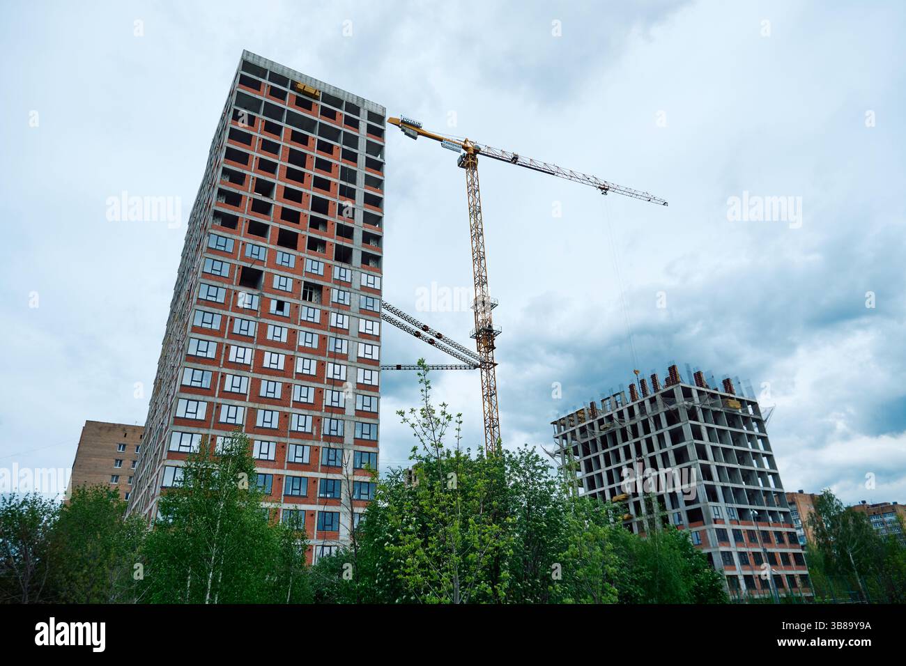 Hochhäuser im Bau und ein Kran gegen den Himmel Stockfoto