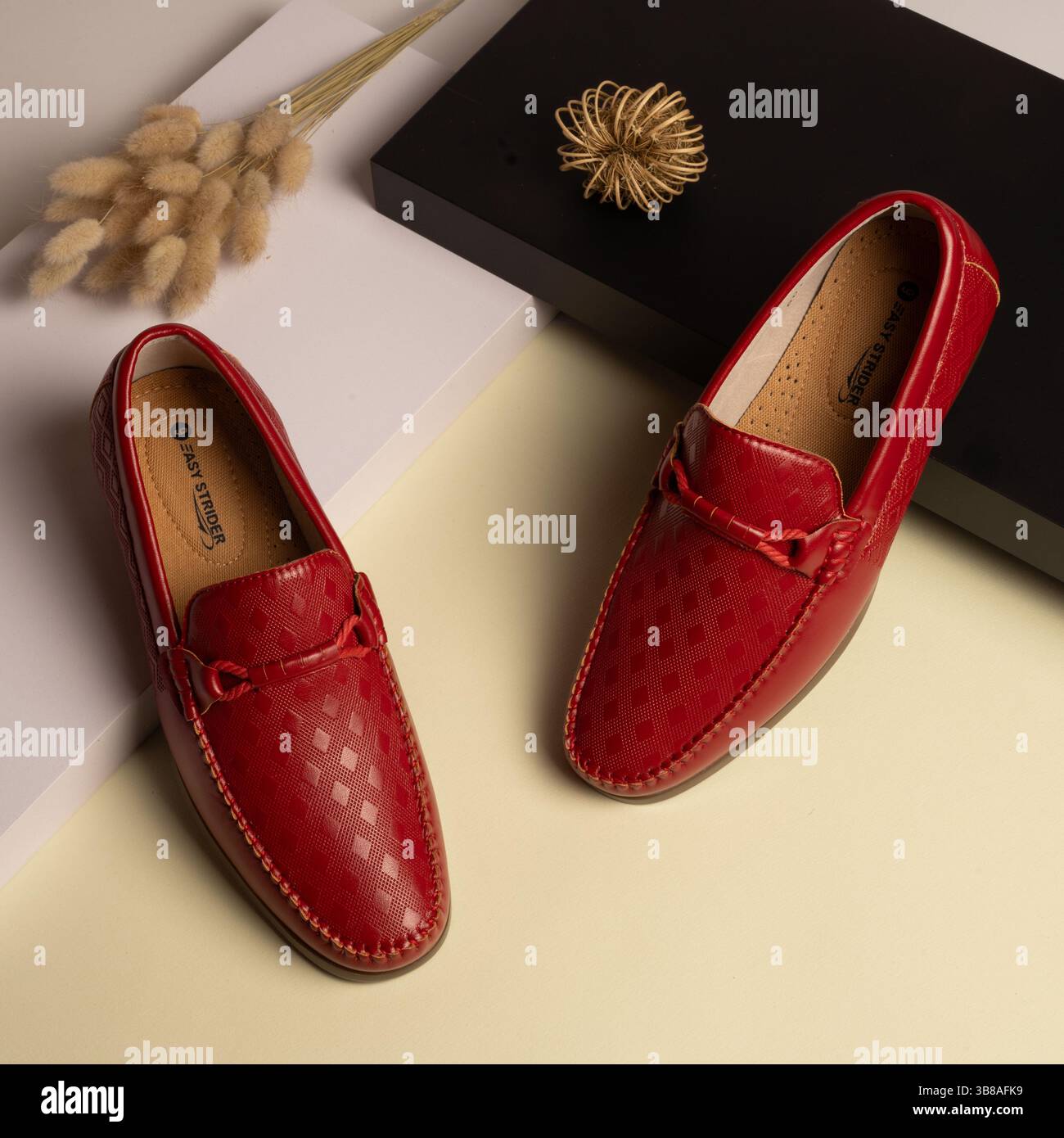 Rote Lederschuhe für Herren mit geometrischer Struktur und passendem Besatz Stockfoto