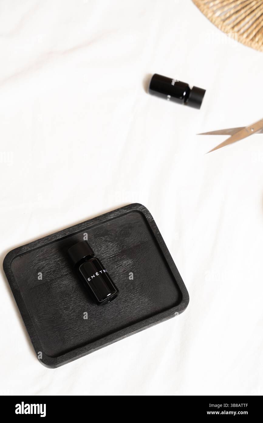 Minimalistisch flache schwarze Flasche und Schere auf weiß Stockfoto