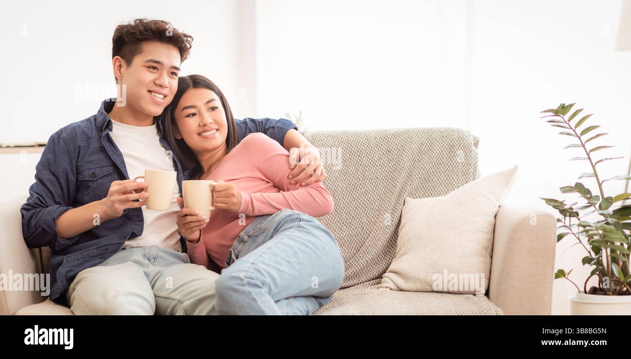 Asiatische Paar Trinken Kaffee Entspannend Sitzen Auf Couch Zu Hause Stockfoto