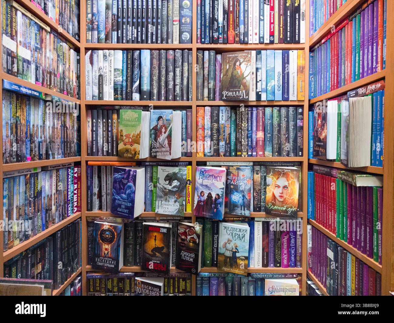 Minsk, Weißrussland - 28. April 2025: Eine gemütliche Ecke mit Regalen voller farbenfroher Romane lädt zum Eintauchen in verschiedene Welten ein. Stockfoto