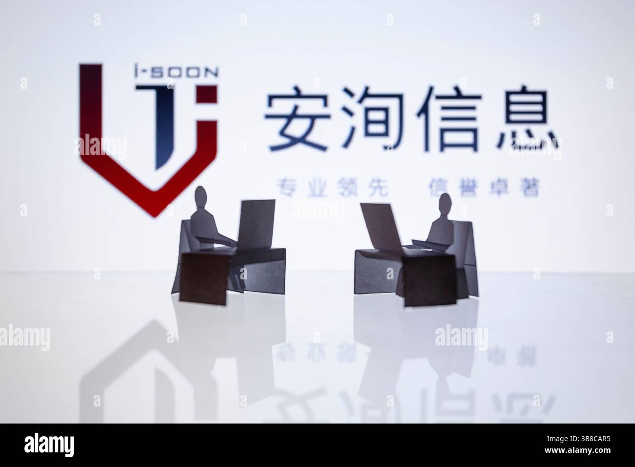 22. Februar 2024, Asuncion, Paraguay: Das i-Soon Logo ist hinter ausgeschnittenen Papierfiguren und Computer-Workstation zu sehen. Interne Dateien, die i-Soon, alias Anxun, einem chinesischen Sicherheitsanbieter, zugeschrieben wurden, der für die chinesische Regierung arbeitet, wurden auf GitHub veröffentlicht. Die Daten haben eine Reihe von Hacking-Tools und -Diensten enthüllt. (Bild: © Andre M. Chang/ZUMA Press Wire) Stockfoto