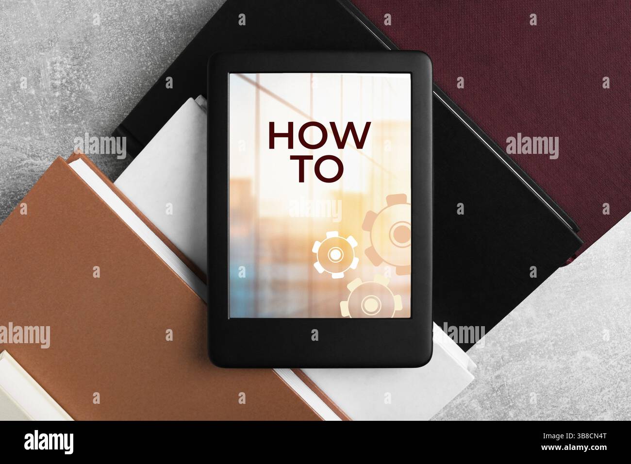 So dokumentieren Sie das Öffnen im E-Book-Gerät und verschiedene Bücher auf einem grauen Tisch, Draufsicht. Benutzerhandbuch Stockfoto