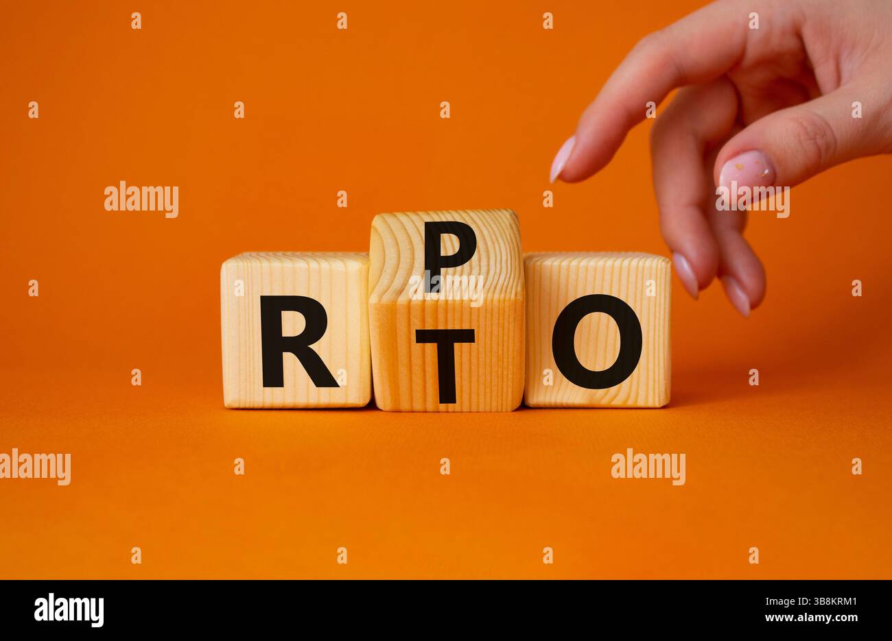 RPO vs. RTO-Symbol. Geschäftsmann zeigt auf gedrehte Holzwürfel mit den Worten RTO zu RPO. Wunderschöner orangefarbener Hintergrund. Geschäftskonzept. Kopierbereich Stockfoto