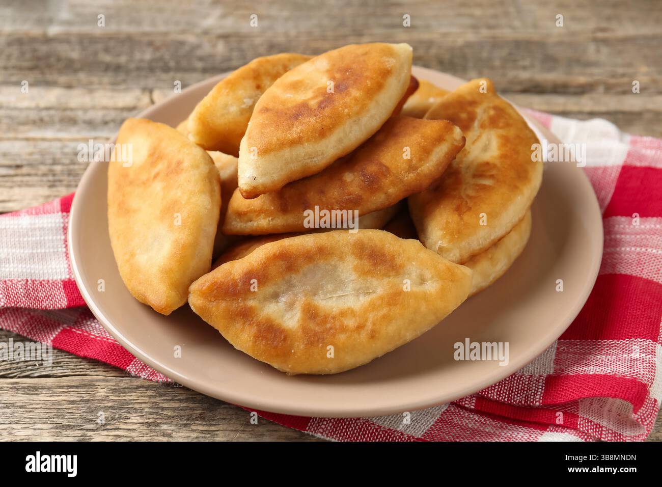 Köstliche gebratene Pyrizhky (gefüllte Kuchen) auf Holztisch, Nahaufnahme Stockfoto Köstliche gebratene Pyrizhky (gefüllte Kuchen) auf Holztisch, Nahaufnahme Stockfoto