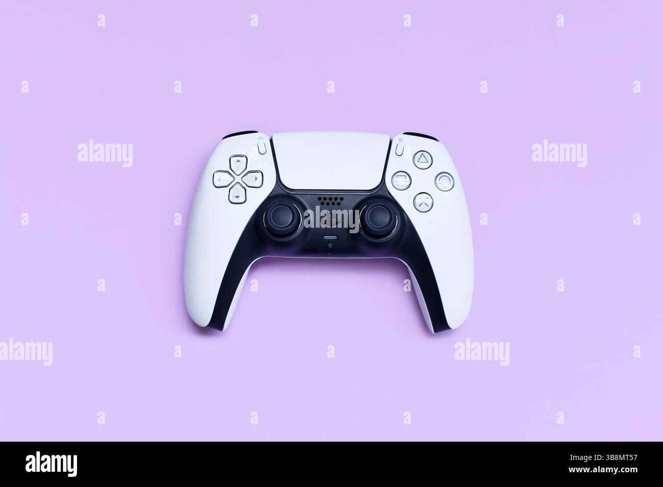 Deutschland – Mai 2025: Weißer PlayStation 5-Gaming-Controller auf pastellviolettem Hintergrund Stockfoto