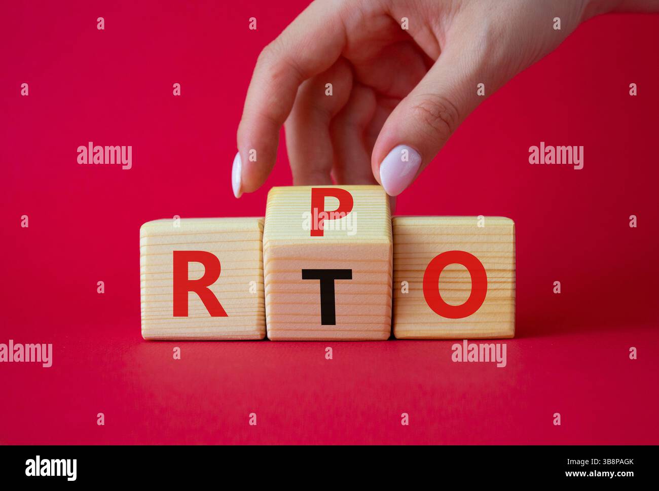 RPO vs. RTO-Symbol. Geschäftsmann-Hand dreht Holzwürfel und ändert das Wort RTO in RPO. Schöner roter Hintergrund. Geschäftskonzept. Kopierbereich Stockfoto