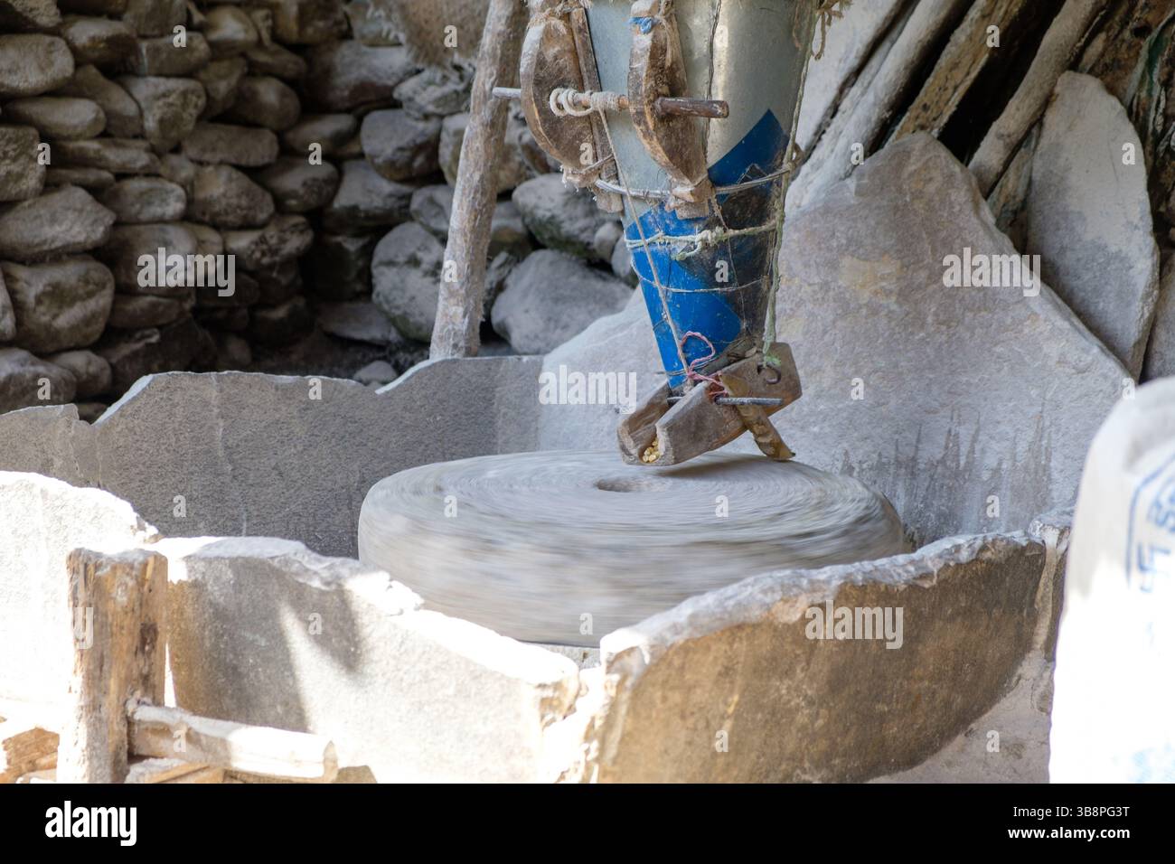 Eine Steinmühle mahlt Getreide. Diese alte Technologie wird zur Verarbeitung von Lebensmitteln verwendet. Stockfoto