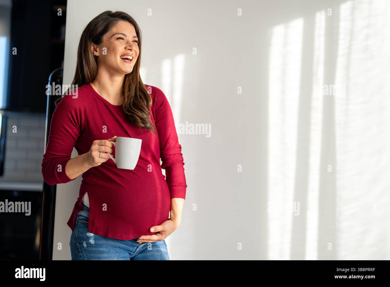 Schwangere Frau, die Entspannung mit einer warmen Tasse Tee praktiziert, Selbstpflege und Wellness zu genießen. Ruhiger, friedlicher Moment während der Schwangerschaft. Stockfoto