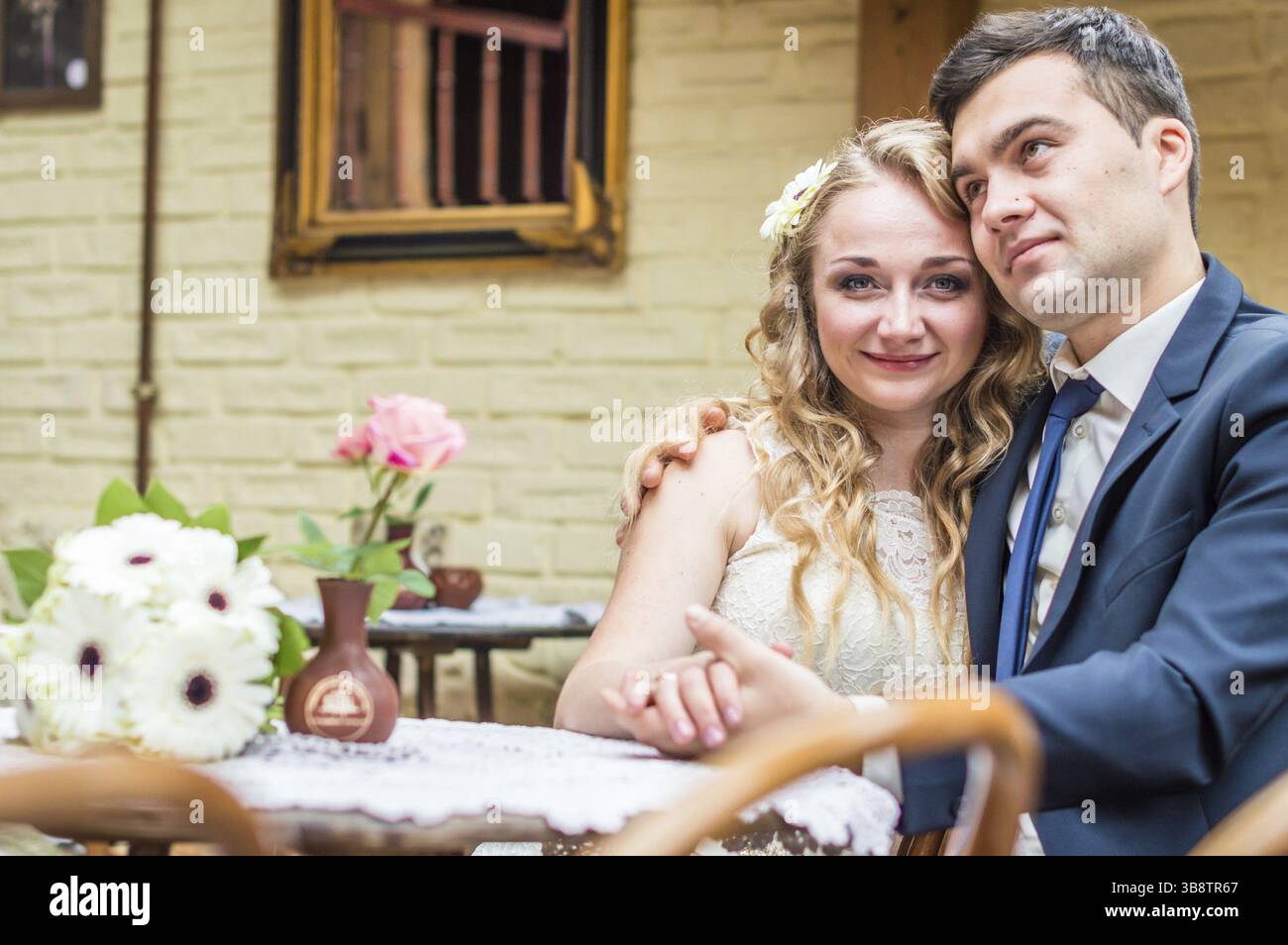 Frisch vermählte sitzen im Café am Tisch Stockfoto