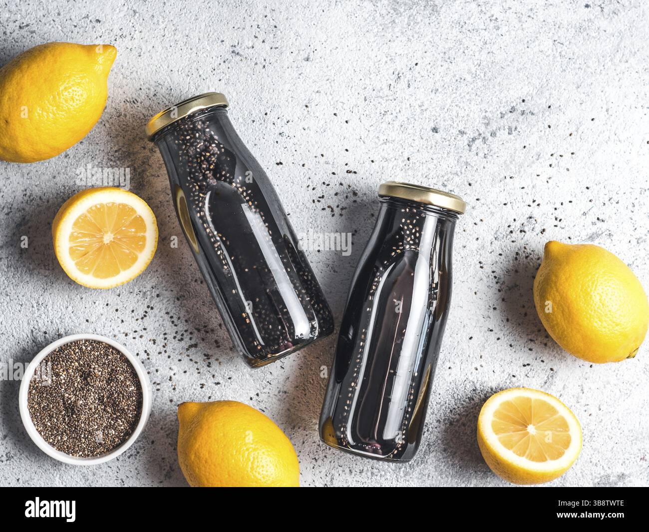 Detox Aktivkohle schwarz Chia Wasser oder Limonade mit Zitrone. Zwei Flaschen Wasser mit schwarzen Chia infundiert. Detox drink Idee und Rezept. Veganes essen ein Stockfoto