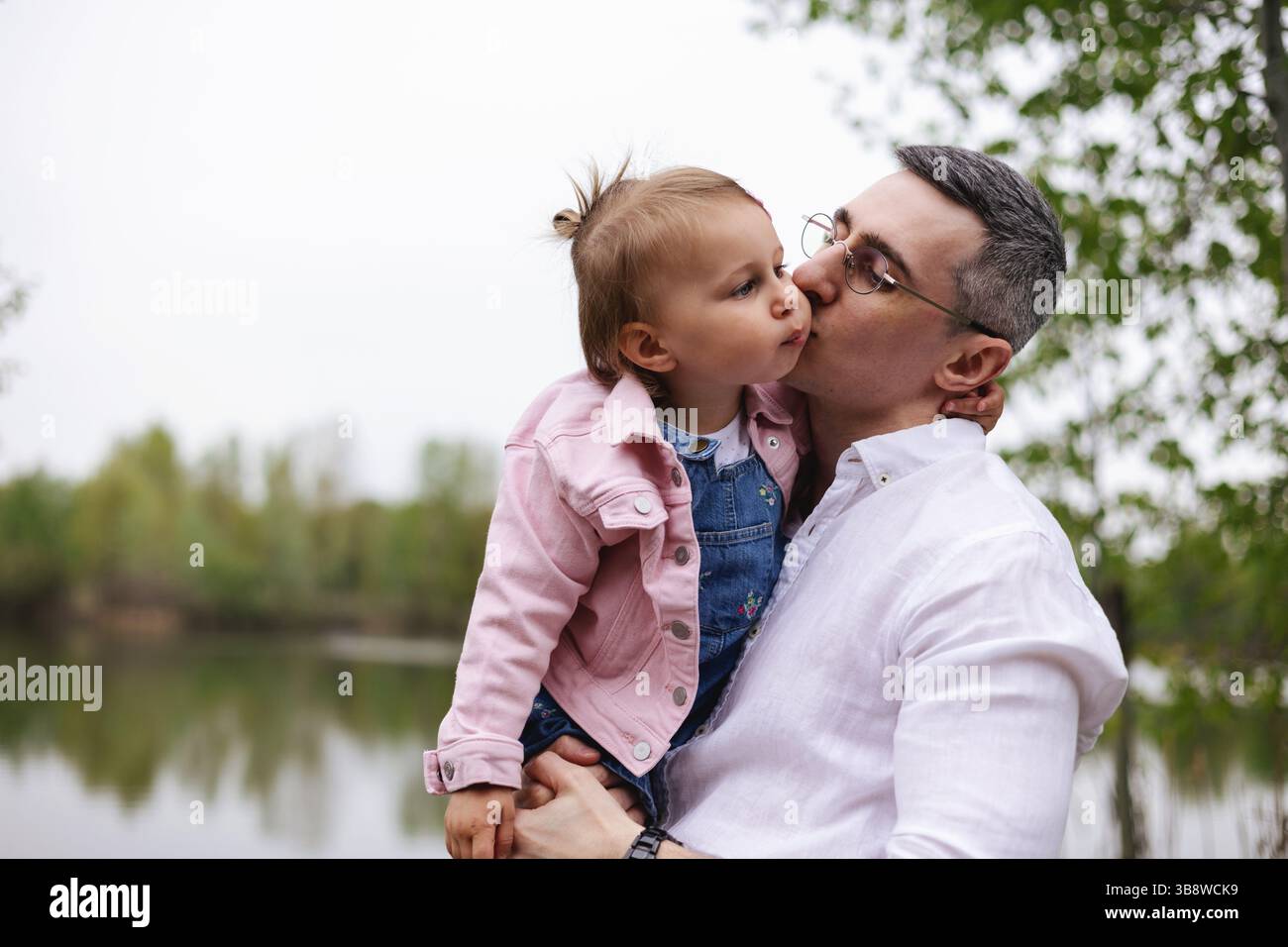Vater und Kind umarmen sich glücklich in der Natur und genießen eine gute gemeinsame Zeit im Freien. Glück, Lachen und Familienliebe Stockfoto