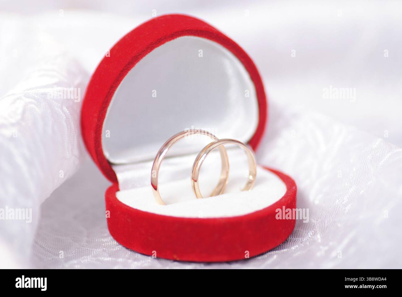 Trauringe auf weißen Textilien. Hochzeit-Postkarte Stockfoto