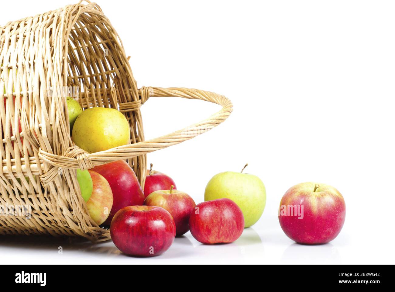 Korb und Äpfel sind auf weißem Hintergrund Streuung. Symbol des Herbstes Stockfoto