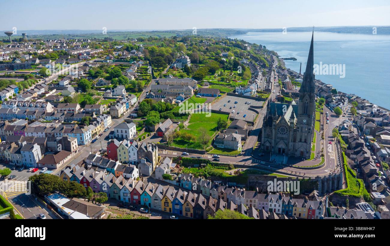 Cobh, Island - 01. Mai 2025: Aus der Vogelperspektive auf die irische Küstenstadt Cobh mit der imposanten St. Colman's Cathedral und den farbenfrohen Häusern auf dem Hügel - ein beliebtes Ziel für Architekturfans, Besucher und Reisende nach Irland. *** Luftaufnahme der irischen Küstenstadt Cobh mit der imposanten St. Colman's Cathedral und bunten Häusern am Hang ein beliebtes Ziel für Architekturfans, Besucher und Irland-Reisende. Stockfoto
