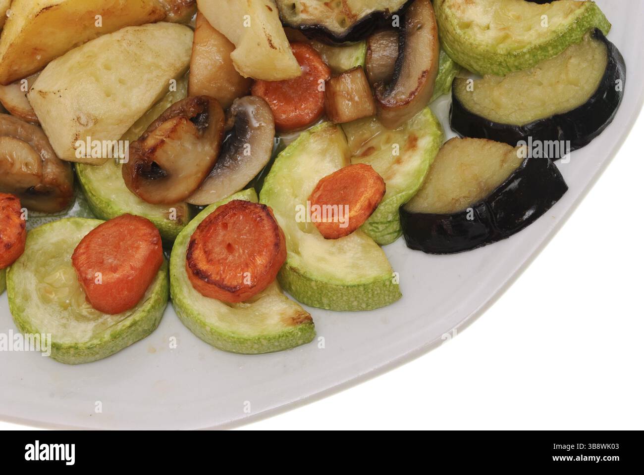Gebackenes Gemüse auf Teller isoliert auf weißem Hintergrund. Vegetarische Speisen Stockfoto