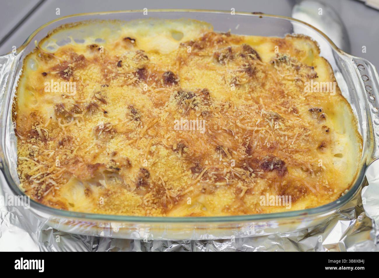 Kartoffelauflauf mit Käse in einer Glasschale Stockfoto