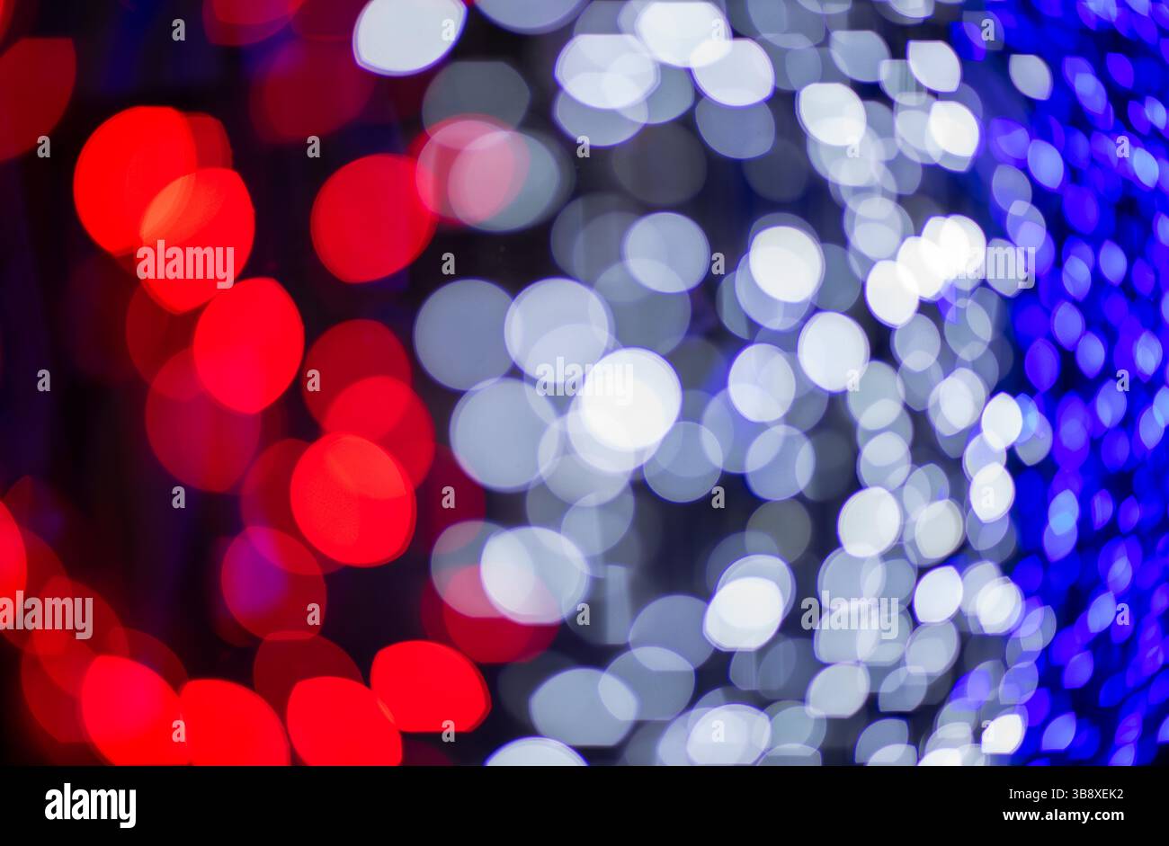Abstrakte bunte Bokeh-Kugeln auf dunklem Hintergrund, lebendiges, defokussiertes Lichtpunktmuster, festliche Overlay-Textur für Fotobearbeitung, unscharfer, heller Zirkus Stockfoto