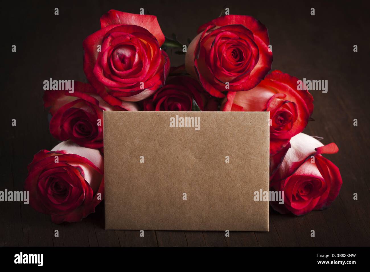 Rosen und leere Handwerkskarte auf dem Tisch Stockfoto