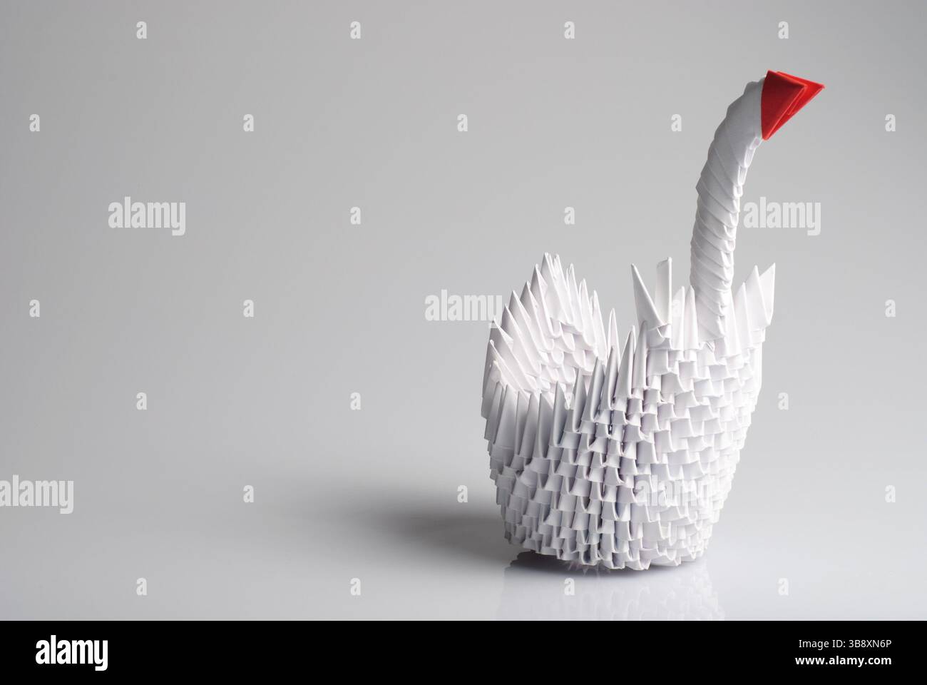Origami Schwan isoliert auf weißem Hintergrund mit Schatten und Reflexion Stockfoto