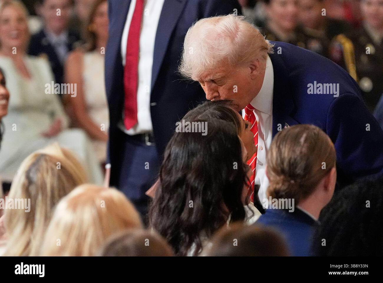 President Donald Trump, right, kisses first lady Melania Trump at an event for Military Mothers, in the East Room of the White House, Thursday, May 8, 2025, in Washington. (AP Photo/Alex Brandon) Stockfoto