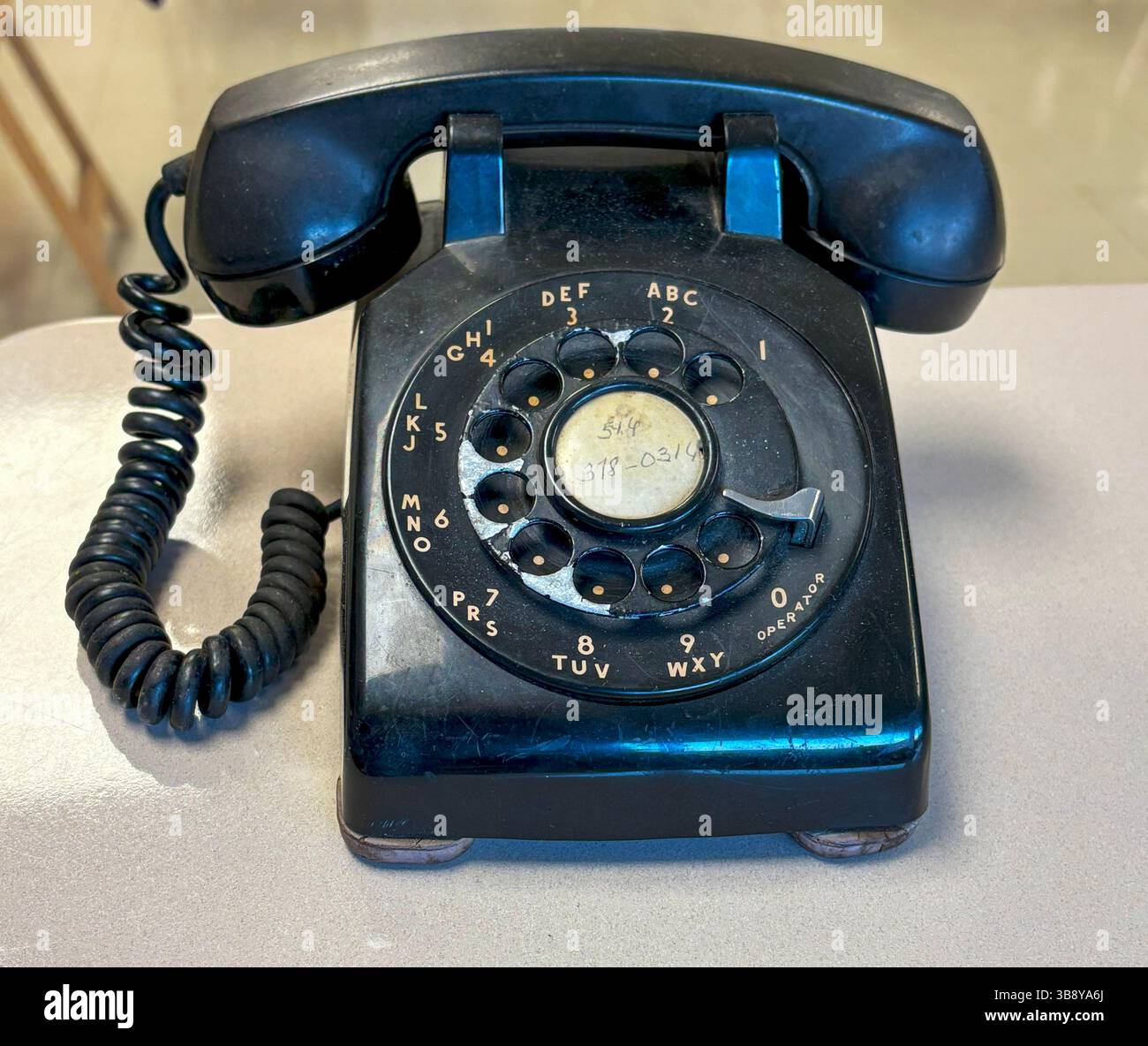 Das klassische Drehtelefon liegt auf einem Tisch und lädt zur Nostalgie und Unterhaltung ein. Stockfoto