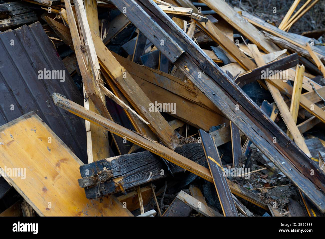 Ein chaotischer Haufen von gebrochenen Holzdielen und Trümmern füllt den Rahmen, was auf Abbruch oder Säuberung im Freien hindeutet Stockfoto