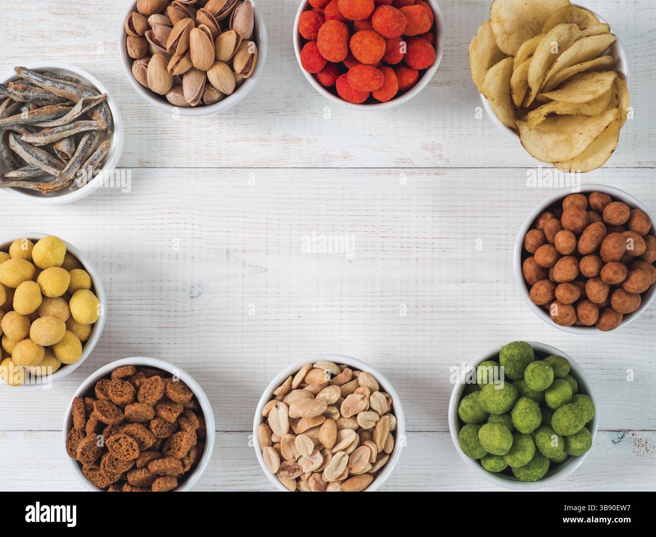 Sortiment von verschiedenen Snack für Bier, Wein, Party. Erdnüsse in Coconut Glasur, grüne vasabi, rote scharfe Chili, gelben Käse Glasur, Chips, Pistazie, Stockfoto