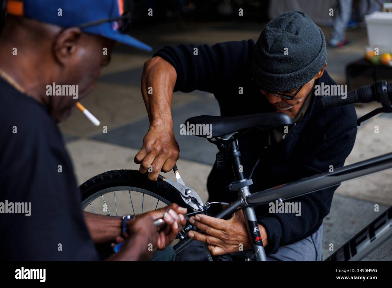 Juli 2023: Von rechts: Huberth Espinoza, 65, und Johnny Lloyd, 61, Arbeiten an einem Fahrrad, das Lloyd am 21. Juni 2023 an Huberth vor der Polizeiwache des 5. Bezirks in Chicago verkaufte. (Bild: © Armando L. Sanchez/Chicago Tribune via ZUMA Press Wire) Stockfoto