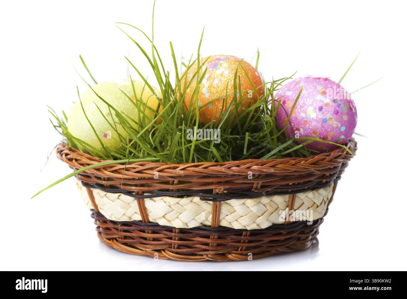 Die ostereier auf frischem grünem Gras im Korb isoliert auf weißem Hintergrund Stockfoto