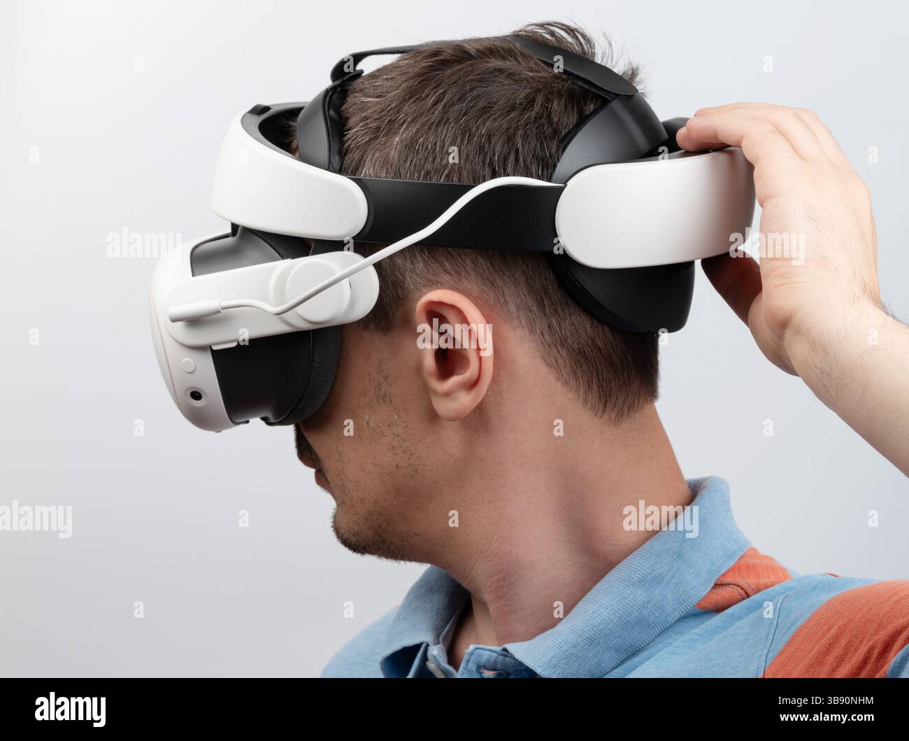 Person, die ein Virtual-Reality-Headset trägt, konzentriert sich auf die immersive digitale Umgebung und zeigt Technologie. Stockfoto