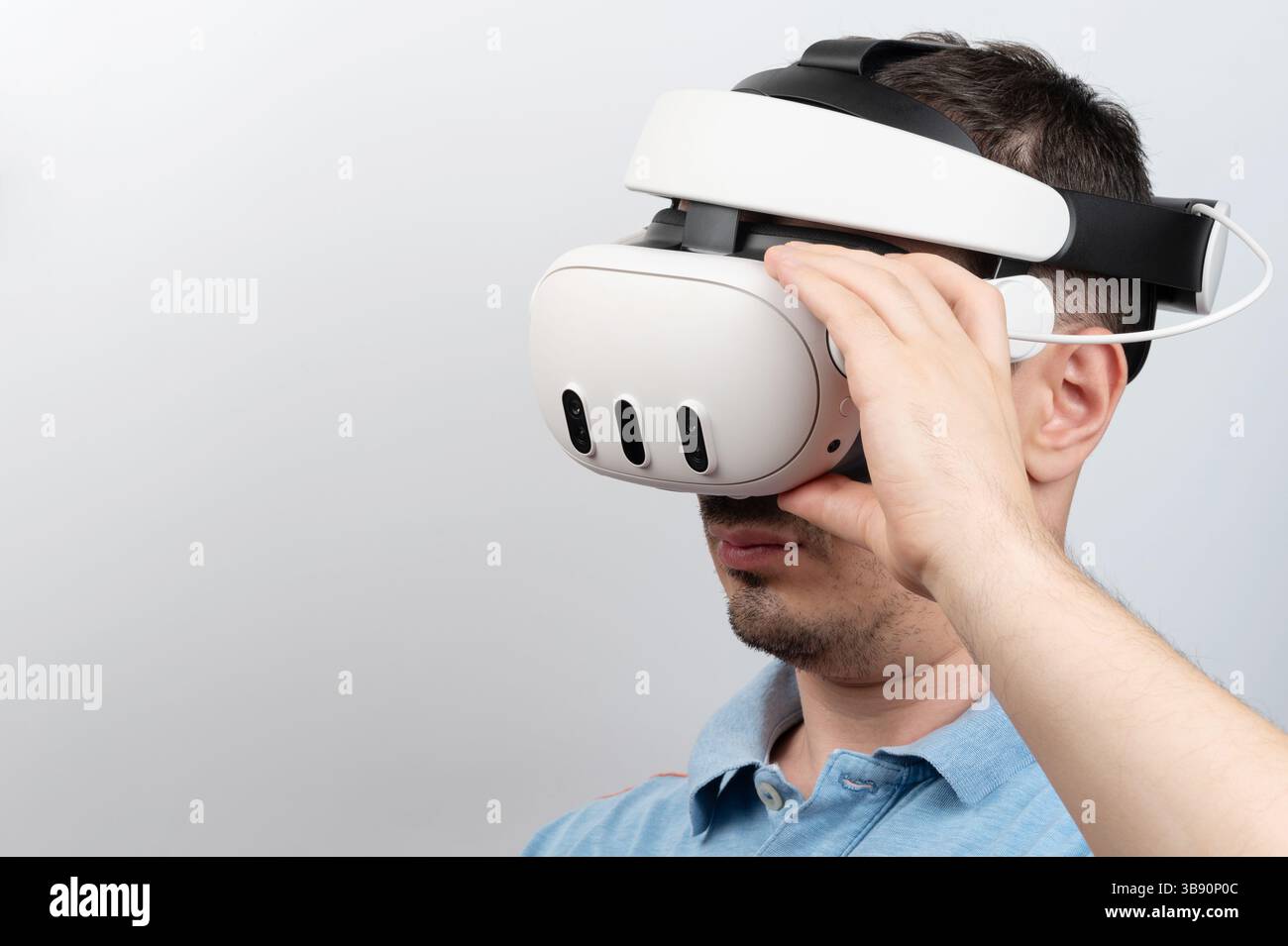Der Mann nutzt das Virtual-Reality-Headset und erkundet faszinierende digitale Umgebungen in hellen Räumen. Stockfoto