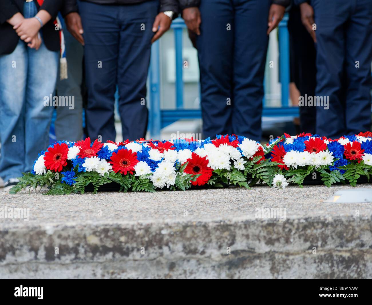 Blaue, weiße und rote Blumenkränze wurden für eine Gedenkzeremonie gelegt, die französische Nationalfarben und eine Gedenkfeier symbolisieren. Stockfoto