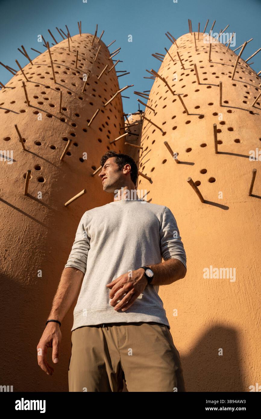 Ein Mann, der vor den traditionellen Taubentürmen im Katara Cultural Village in Doha, Katar, steht Stockfoto