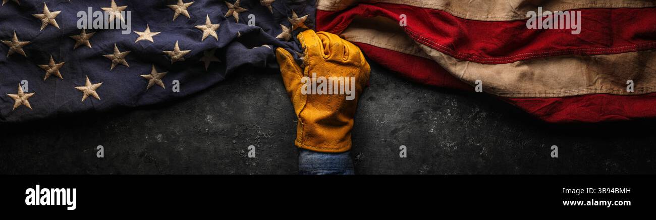 Abgenutzter Arbeitshandschuh mit alter US-amerikanischer Flagge. Made in USA, American Workforce, Blue Collar Worker oder Labor Day Concept. Stockfoto