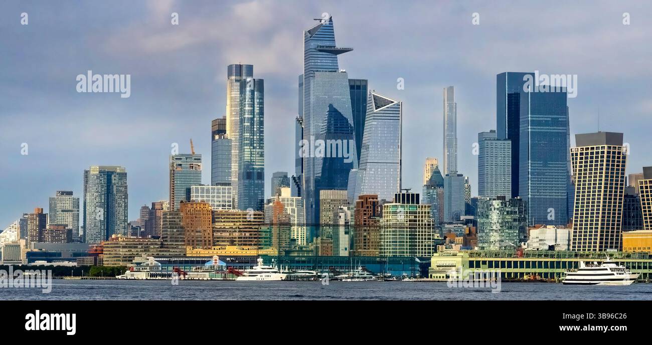 Die pulsierende Skyline von New York City bietet eine Mischung aus modernen Wolkenkratzern und älteren Gebäuden vor einem bewölkten Himmel. Boote können auf dem Wasser im gesehen werden Stockfoto