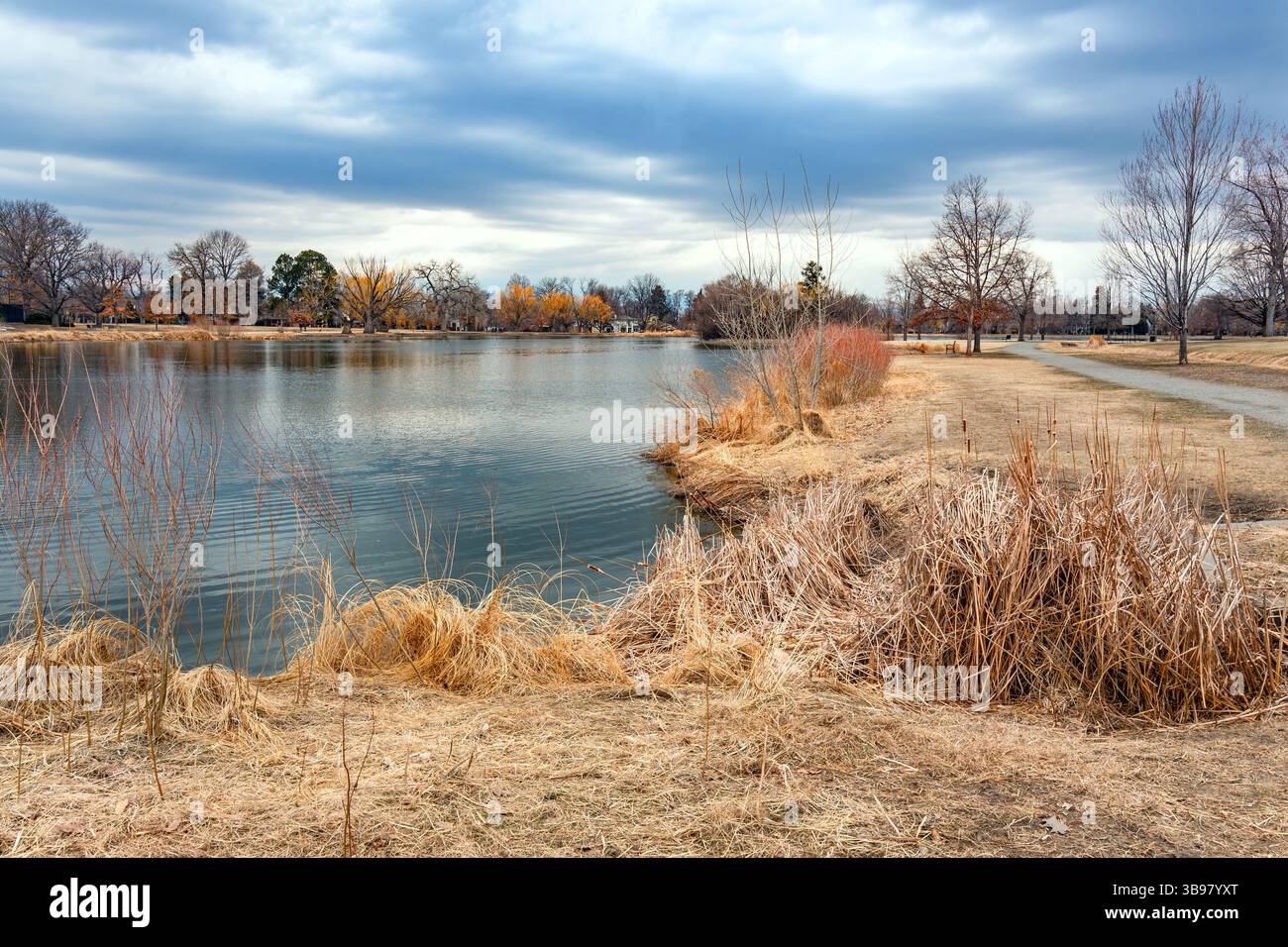 Ein malerischer Blick auf den Washington Park in Denver, Colorado, mit der ruhenden Vegetation und den Wanderwegen rund um den Grasmere Lake an einem friedlichen Wintertag. Stockfoto