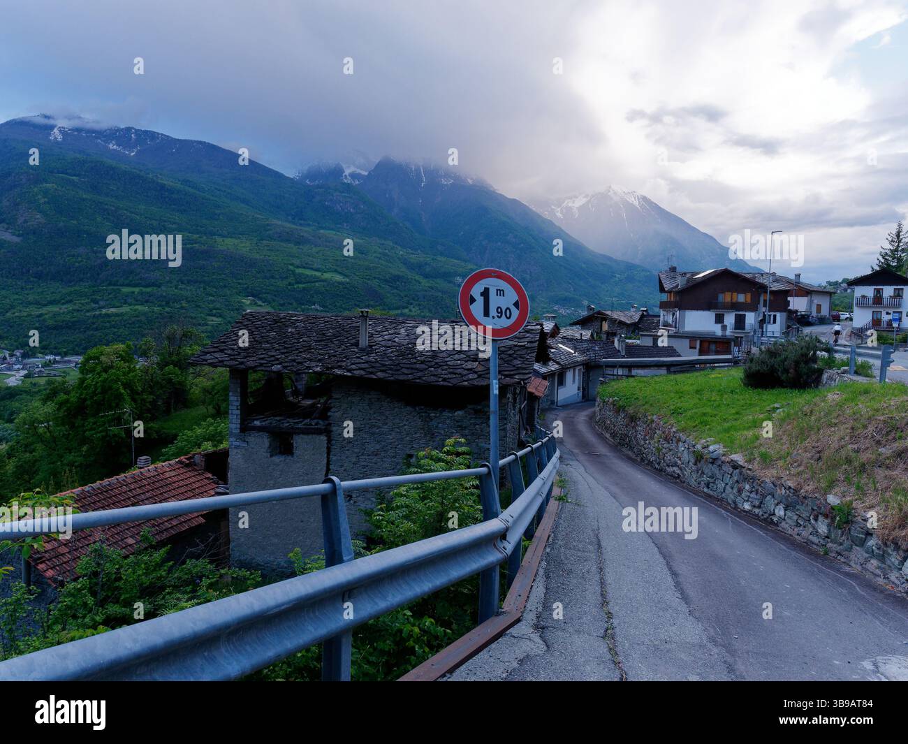 Ländliches Dorf und Straße mit Bergen hinter NUS im Aostatal, Italien. Mai 2025 Stockfoto