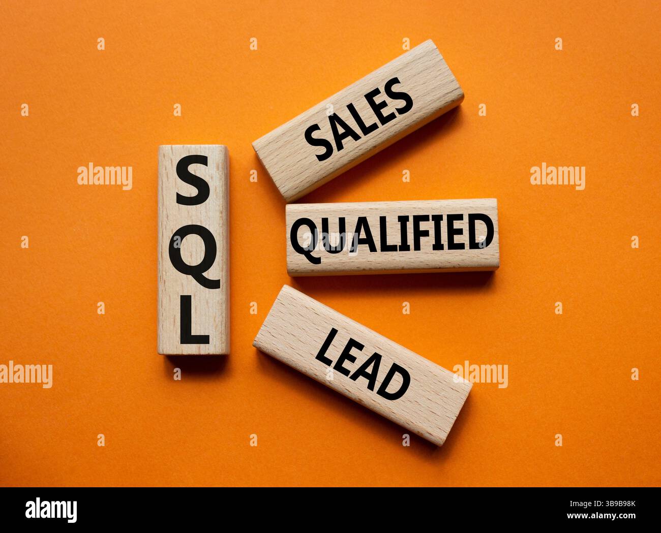 SQL - qualifizierter Lead für Vertrieb. Holzwürfel mit SQL-Wörtern. Wunderschöner orangefarbener Hintergrund. Business- und SQL-Konzept. Kopierbereich. Stockfoto