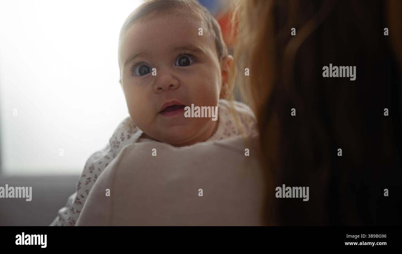 Frau, die das Baby in gemütlicher Wohnzimmeratmosphäre hält, hebt die Liebe der Mutter Tochter und die Familienbindung hervor, mit einer warmen Atmosphäre, reich an emotionaler Tiefe und Stockfoto