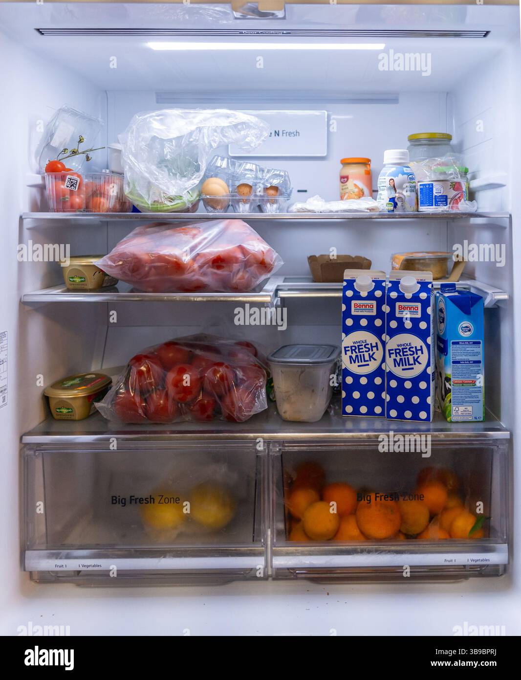 Organisierter Kühlschrank mit frischen Produkten, Milchprodukten und Getränken Stockfoto